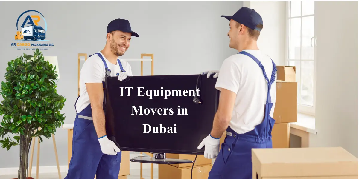 Professional IT equipment movers in Dubai carefully transporting a large computer monitor during an office relocation using safe handling techniques and protective equipment.